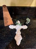 Front view of all three items: wood metronome, ornate wall cross, metal dog figurine on marble base