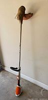 Full view of STIHL cordless string trimmer leaning against wall