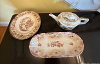 All three items grouped: brown transfer dinner plate, oval floral relish dish, Bavaria fruit teapot