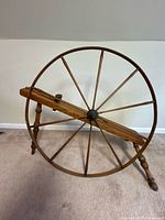 Full side view of spinning wheel showing entire structure and large wheel