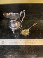 Creamer and serving spoon together with scale reference