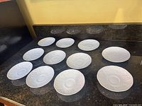 Top view of ten saucers showing embossed Strawberry & Vine pattern