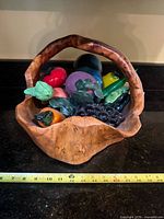Basket bowl filled with decorative fruit, tape measure showing width