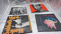 All four LPs laid out: Queen, Rolling Stones, Black Sabbath Paranoid, Black Sabbath Vol.4