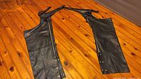 Chaps laid flat showing both legs, waist strap visible