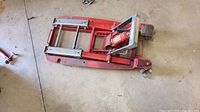 Full view of red motorcycle-ATV jack in folded position