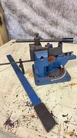 Overall view of metal bender body on base with rusted steel components and detached blue handle