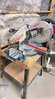 Bosch miter saw with dust bag on stand