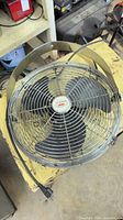 Top view showing complete metal hanging fan, grille, blades, power cord and plug