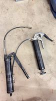 Both grease guns showing overall form and hoses