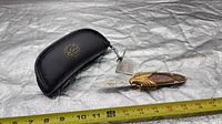 Knife opened beside Franklin Mint pouch showing overall design