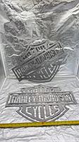 Both steel Harley-Davidson wall signs displayed together