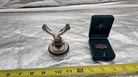 Front view showing eagle figurine and badge with ruler for scale