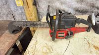 Full view of Jonsered chainsaw with bar, chain, and bar cover on workbench
