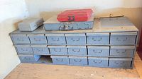 Front view of 18-drawer steel cabinet with three cases on top