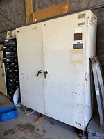 Front view of tall metal cabinet with double doors and stickers