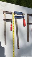 All three bar clamps laid out with tape measure for scale