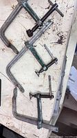 All three steel F-style bar clamps laid out showing overall form and screw mechanisms