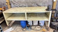 Full view of steel workbench with vise, casters, lower shelf