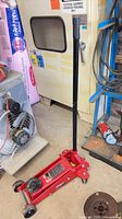 Full view of red Torin floor jack with handle attached