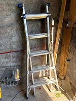 Ladder folded and standing against wall