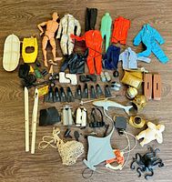 All items laid out on floor including figure, clothing, skis, dive gear, sea creatures
