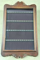 Full view of closed display case showing wood frame, carved details and glass door