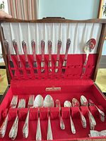 Open presentation chest displaying full array of flatware pieces in slots