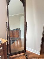 Front view of full-length carved wood mirror