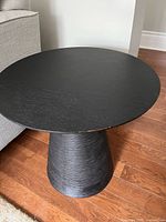 Top and base of black pedestal end table