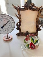 Group view of thermometer-hygrometer, antler frame, and glass feeder