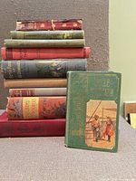 Stack of nine antique cloth-bound books with Uncle Tom’s Cabin displayed front