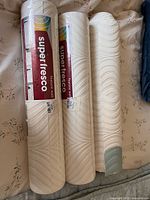 Three sealed wallpaper rolls overall view