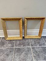 Two matching gold gilded wood frames side by side