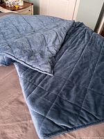 Full view of blue weighted blanket spread on bed