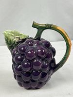 Right side view showing grape cluster body, vine handle, leaf spout