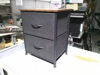 Full view of two-drawer fabric storage table showing wood top, fabric drawers, metal frame