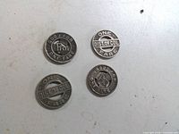 Front view showing all four tokens: two marked Good For One Fare PRT, two marked One Fare Dist. of Col.