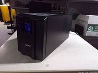Front left perspective of UPS showing APC logo and LCD screen