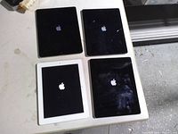 Four iPads laying screen-up on table