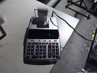 Full view of Canon MP25DV printing calculator with paper roll and power cord