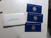 Group shot of three blue-card pewter medallions and Interphil ’76 cover