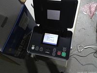 Printer powered on with lid open showing control panel and LCD