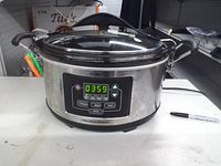 Front view showing stainless body, control panel lit, Hamilton Beach branding
