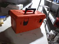 Closed orange Homer Box toolbox on table