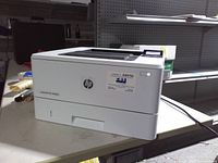 Front and side view of HP LaserJet Pro M402n printer on table
