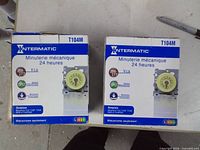 Front view of both Intermatic T104M boxes showing model, voltage 208-277 V and timer image