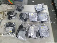 Ten individually bagged Jabra USB headsets on table
