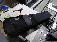 Closed Max violin case on table showing logo and exterior pocket