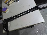 Pair of collapsed black trekking poles with grips and straps